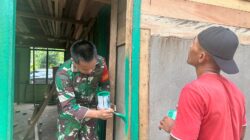 Dan SSK Satgas TMMD Bantu Pengecatan Kusen Pintu RTLH di Kampung Linggang Amer