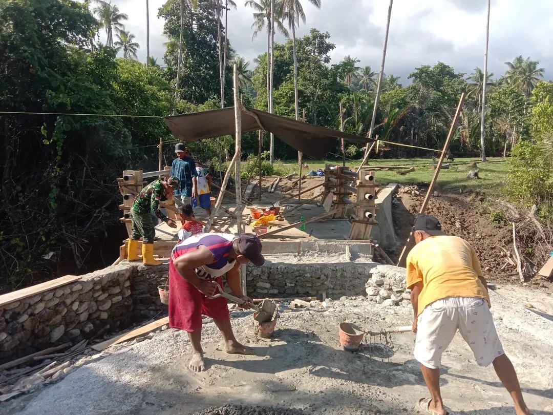 Anggota Kodim 1505/Tidore dan Warga Gotong Royong Cor Tiang Pembatas Jembatan Garuda di Desa Gita